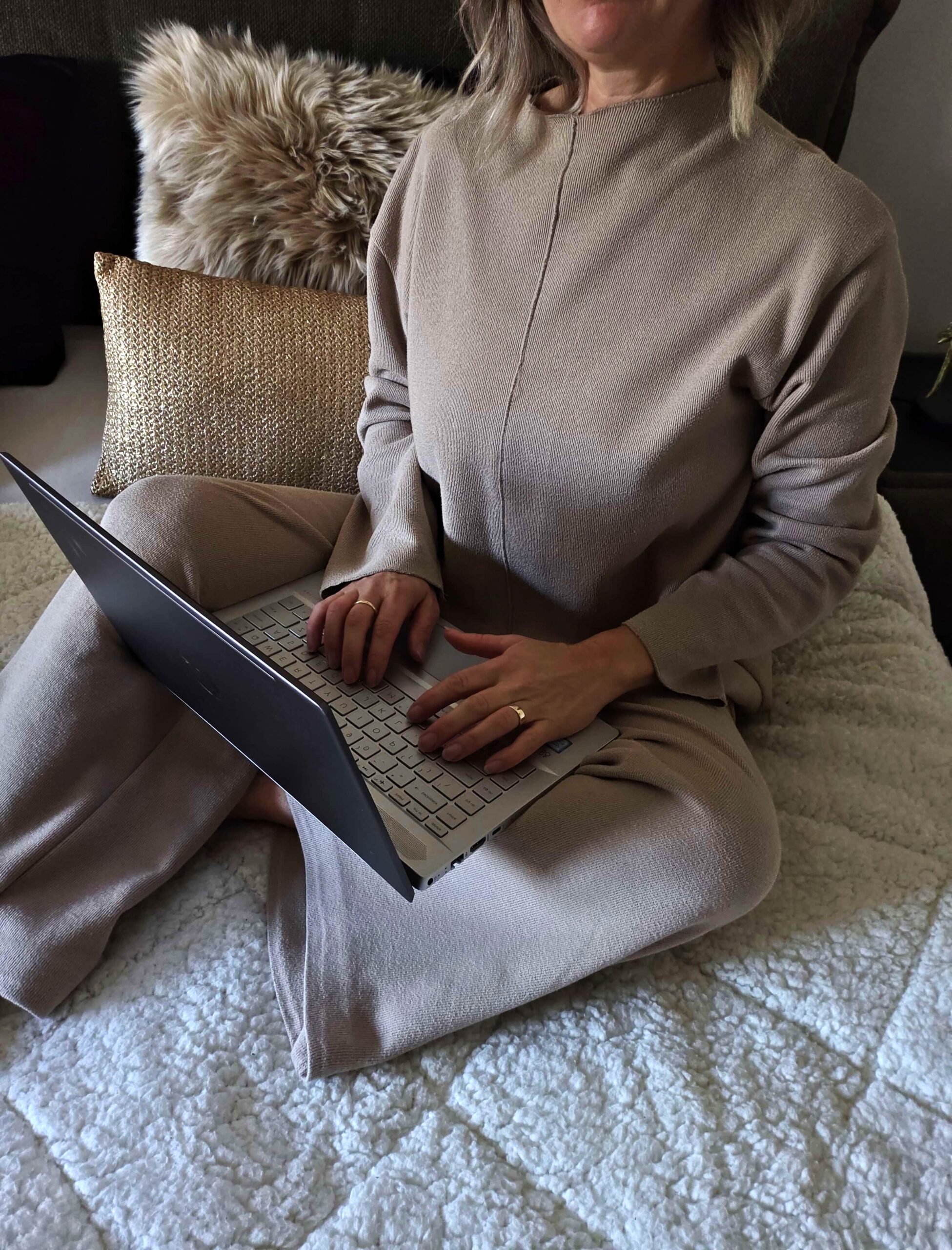 Ondernemer zit op bed met laptop en werkt in een rustige omgeving